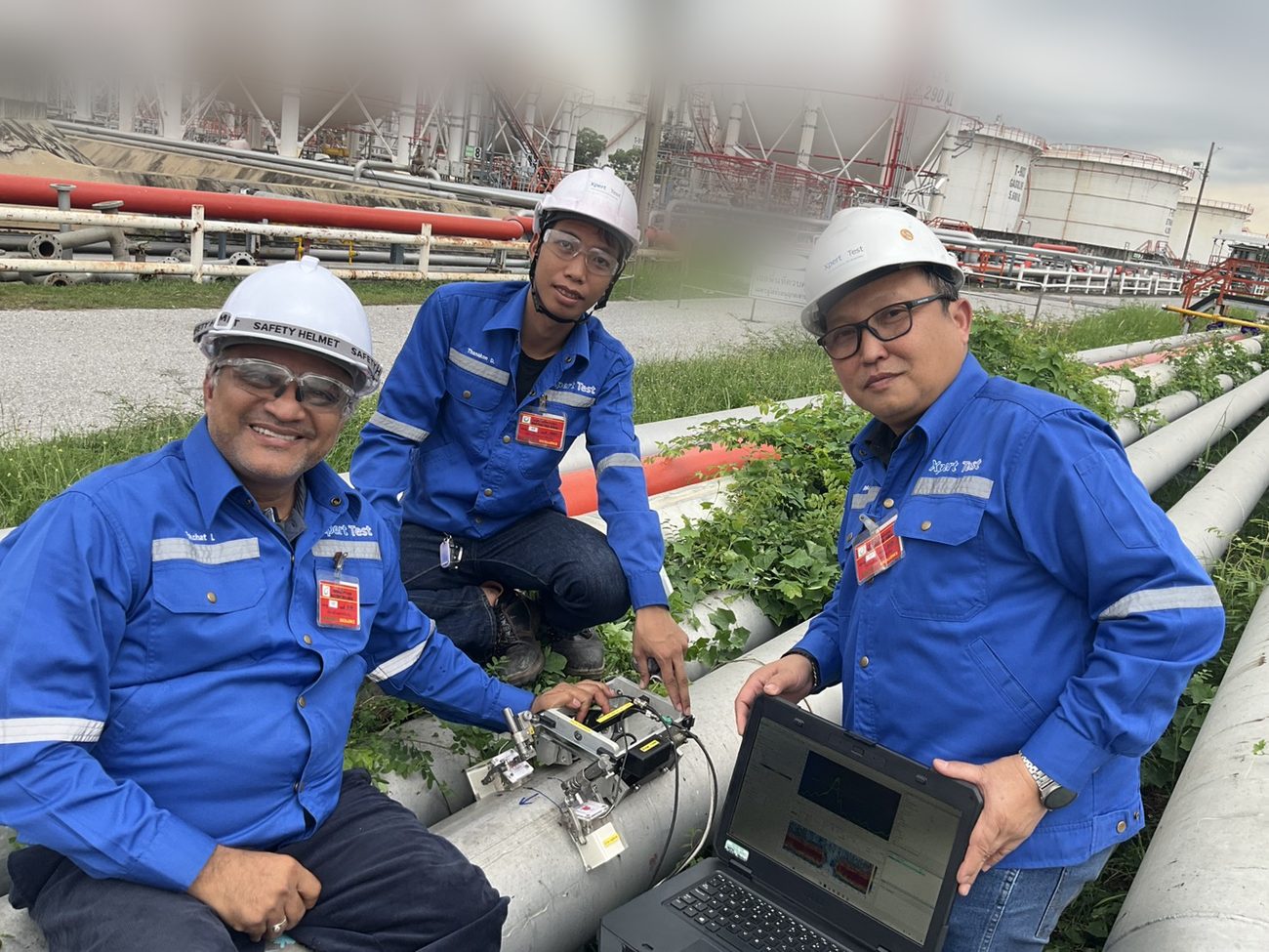 Expert Test inspectors performing guided-wave ultrasonic corrosion inspection on piping at a Rayong tank farm